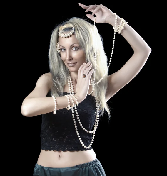 Vacker ung blond kvinna med långt hår och en pärla dansar en orientalisk dans på mörk bakgrund — Stockfoto