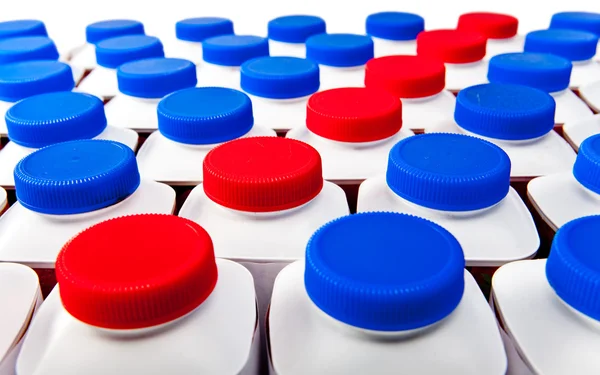Dairy products bottles stand in rows, bright covers — Stock Photo, Image