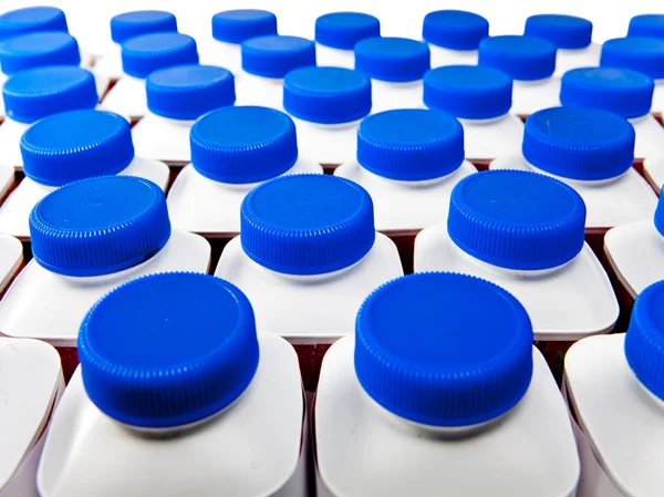 Dairy products bottles stand in rows, bright covers — Stock Photo, Image