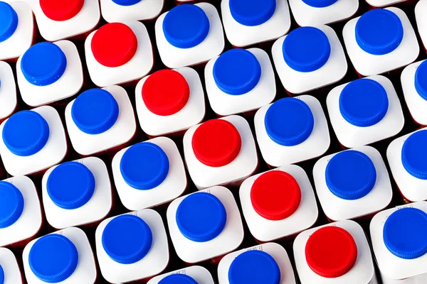 Dairy products bottles stand in rows, bright covers — Stock Photo, Image