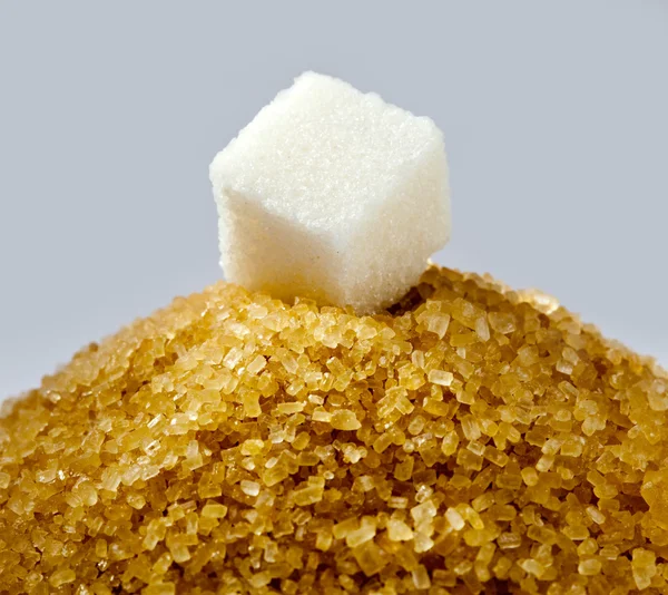 Sugar cube on a heap of granulated sugar — Stock Photo, Image