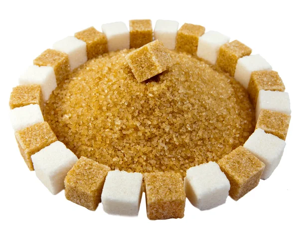 Cubes of sugar lie on circles and a heap of granulated sugar inside — Stock Photo, Image