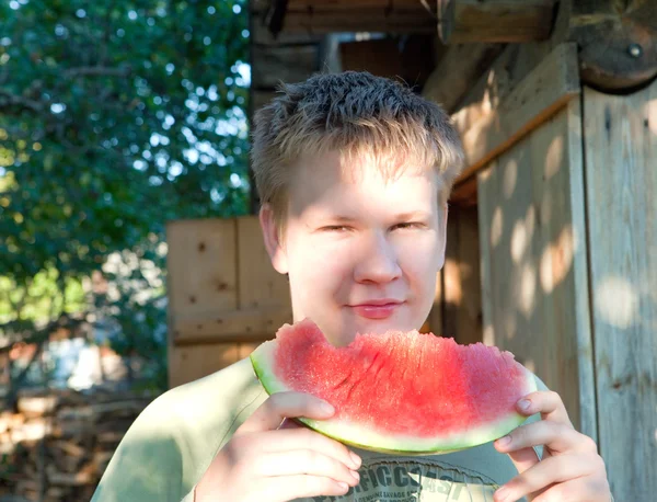 L'adolescent mâle mange un melon d'eau — Photo