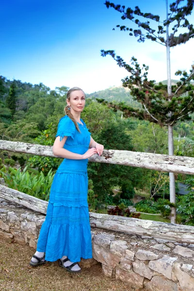 Cuba. The beautiful woman in a long blue dress in park of Soroa (Jardin Botanico Orquideario Soroa) — Stock Photo, Image