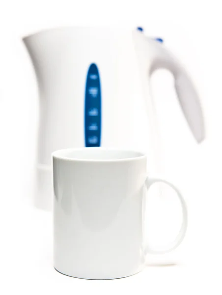 Focus on a tea mug. Electric tea kettle on a white background and a mug — Stock Photo, Image