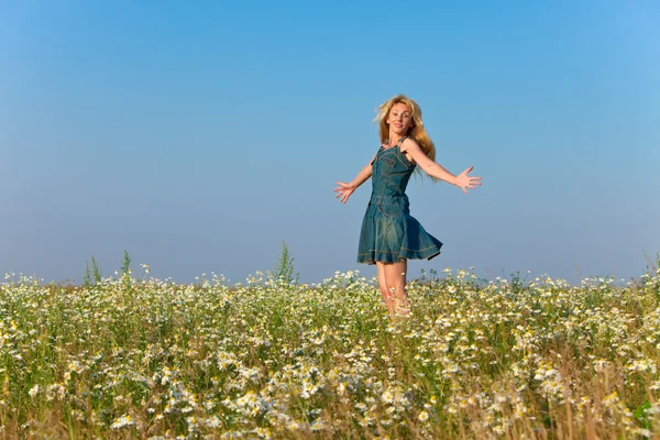 The happy young woman in the field of camomile — Stock Photo, Image