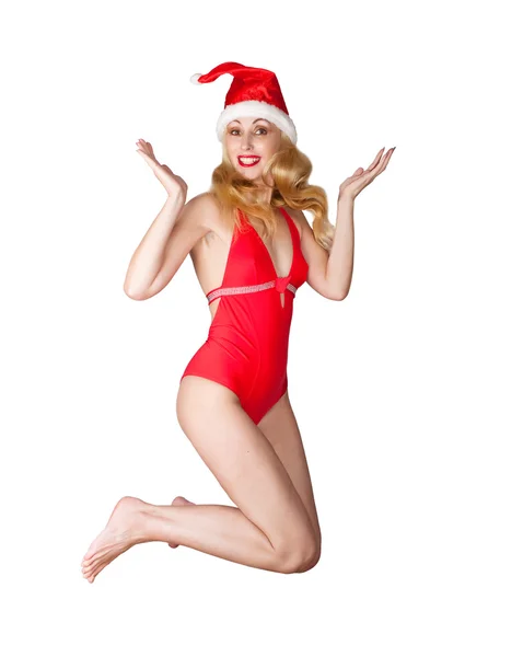 A mulher bonita em um maiô vermelho e um boné vermelho de Papai Noel — Fotografia de Stock