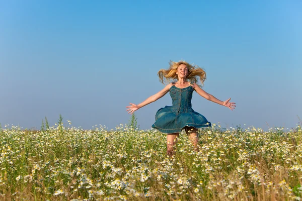 The happy young woman in the field of camomile — Stock Photo, Image