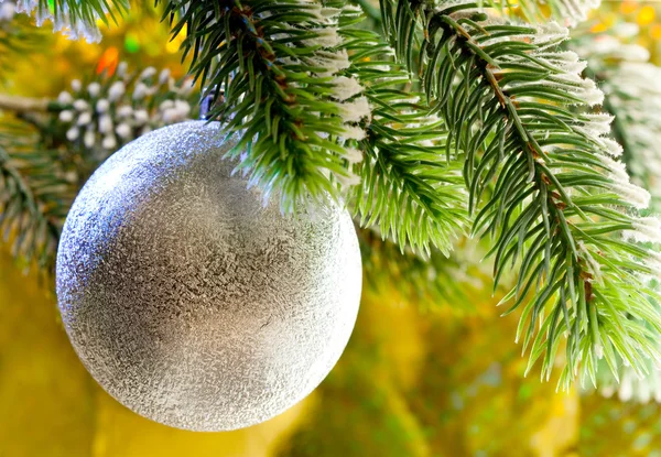Mooie zilveren new year's ball op een tak van een kerstboom — Stockfoto