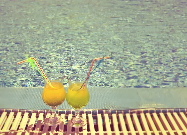 Copos com coquetel na borda da piscina, com um efeito retro — Fotografia de Stock