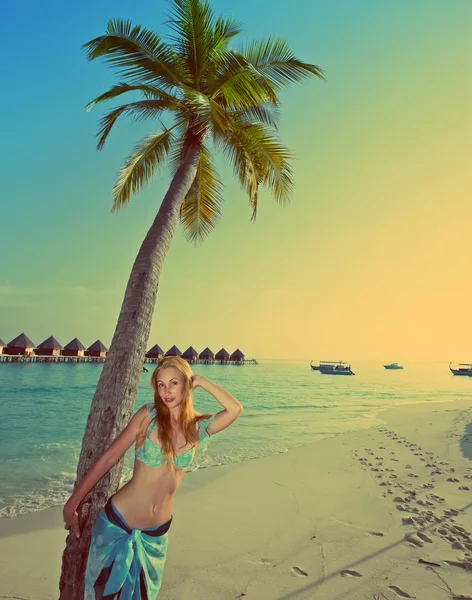 Jovem mulher bonita fica perto de palmeira, Maldivas, com um efeito retro — Fotografia de Stock