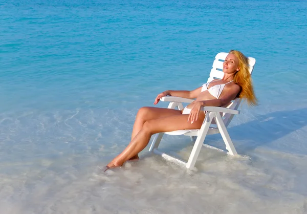 年轻漂亮的女人晒黑的沙滩椅 — 图库照片