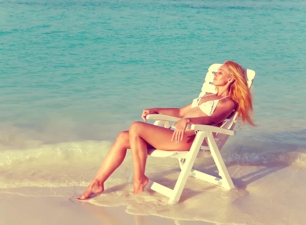 Giovane bella donna abbronzatura in spiaggia sedia — Foto Stock