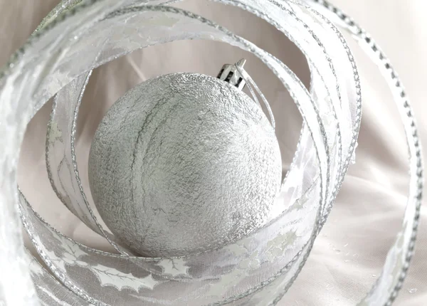 Красивый серебристый новогодний бал и декоративная лента — стоковое фото