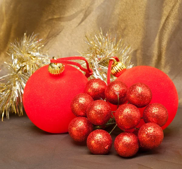 Red New Year's ball, decorative berries and tinsel — Stock Photo, Image