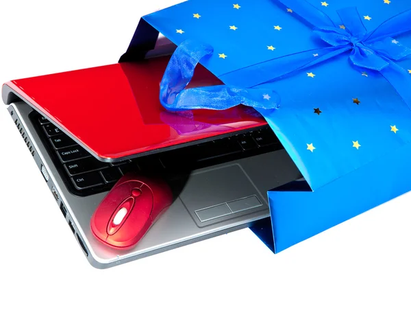 Red laptop and a computer mouse are packed into a gift packet by New yea — Stock Photo, Image