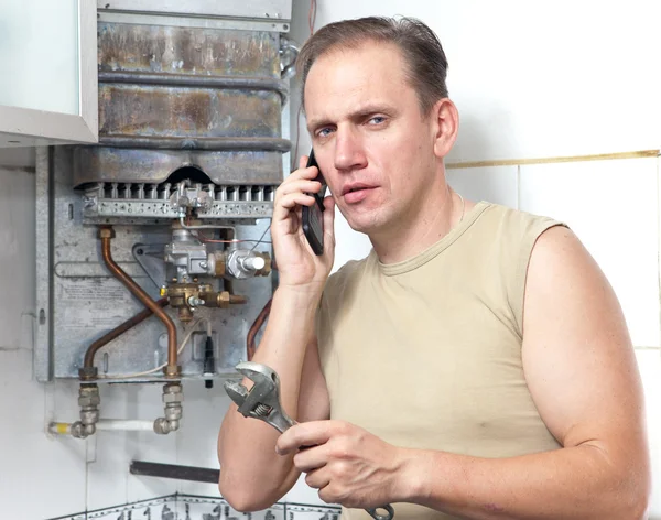 Mannen samtal per telefon att orsaka reparatör av gas vattenvärmaren — Stockfoto