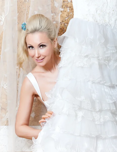 Die junge Frau in der Nähe eines Brautkleides träumt von der Hochzeit — Stockfoto