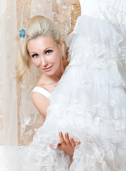 Молодая женщина рядом со свадебным платьем мечтает о свадьбе — стоковое фото