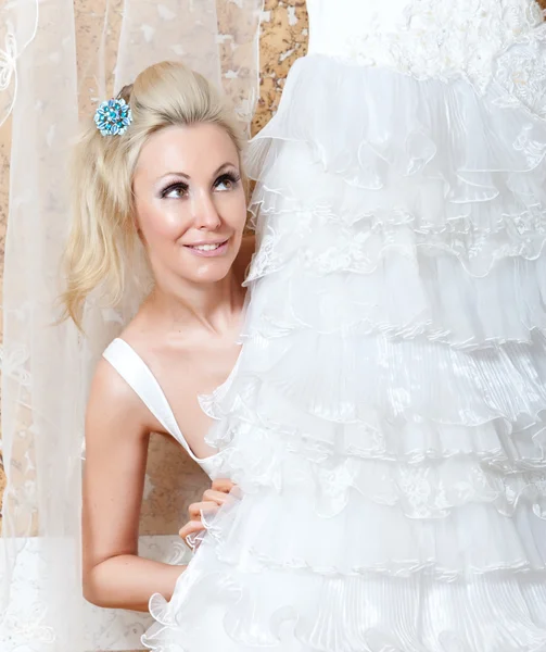 A mulher jovem perto de um vestido de casamento sonha com o casamento — Fotografia de Stock