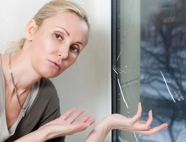 La triste joven cerca de una ventana con el vidrio roto — Foto de Stock