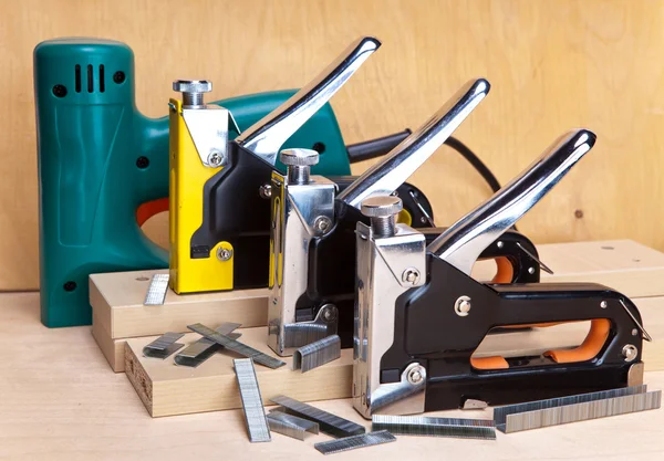 La herramienta - grapadoras eléctricas y mecánicas manuales - para trabajos de reparación en la casa y en los muebles, y soportes —  Fotos de Stock