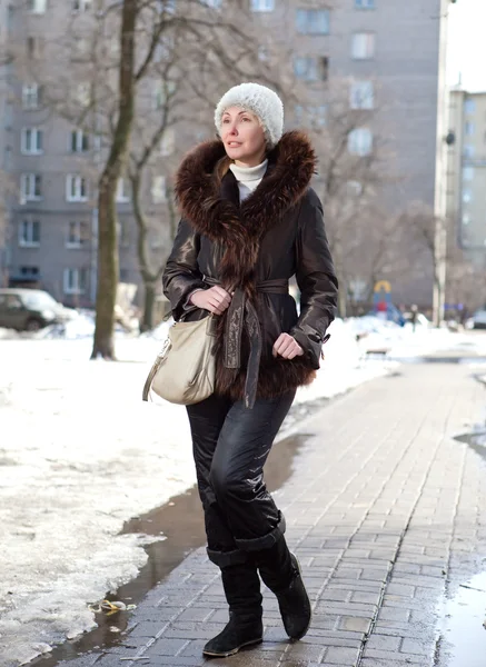 A fiatal nő egy az utcán a tél szőrme galléros kabát — Stock Fotó