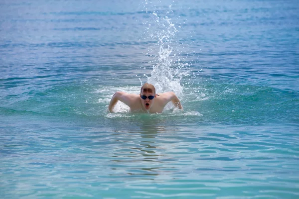 Junger Sportler schwimmt im Schmetterlingsschlagstil. — Stockfoto