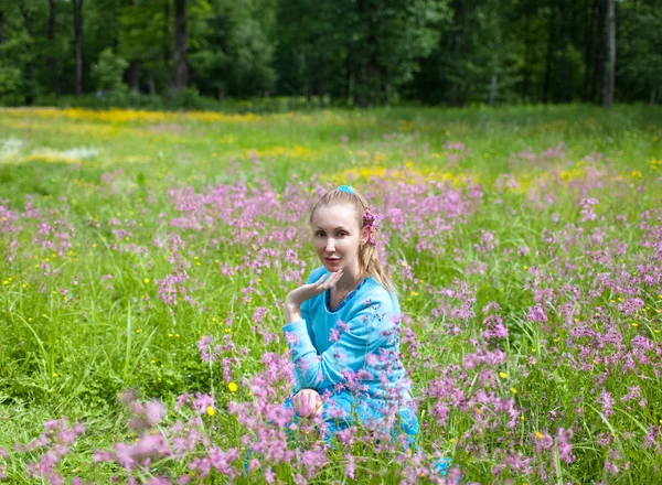 The happy young woman in the field of wild flowers — Stock Photo, Image