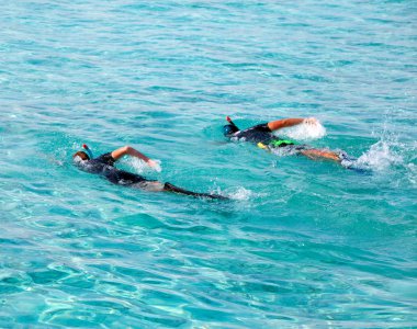 maskeleri ve tüpler ile iki adam, zaman uyumlu olarak denize yüzmek