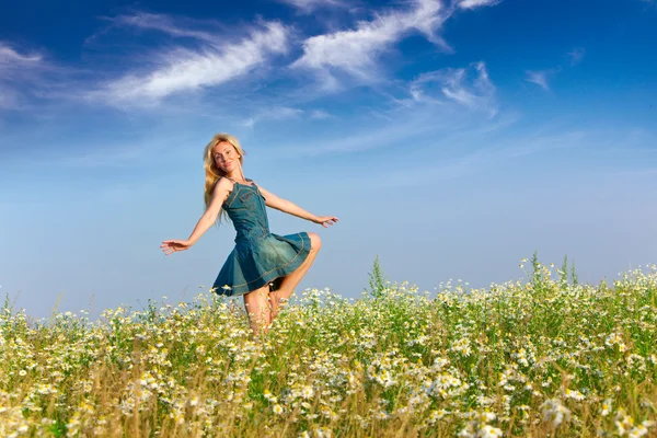 La joven feliz salta en el campo de las manzanillas — Foto de Stock