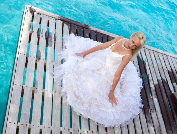 Die junge schöne Frau im Kleid der Braut rennt auf den Wellen des Meeres — Stockfoto