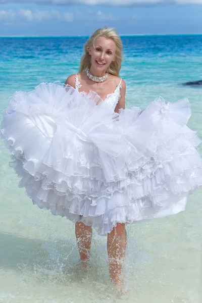 Mladá krásná žena v šatech nevěsty běží na vlnách viz — Stock fotografie