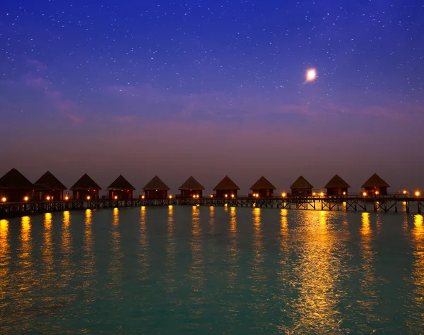 Casas en pilas en el agua en la noche en la luz de la luna tonto — Foto de Stock