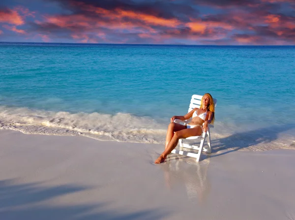 Joven bonita mujer en una silla de playa en el océano —  Fotos de Stock