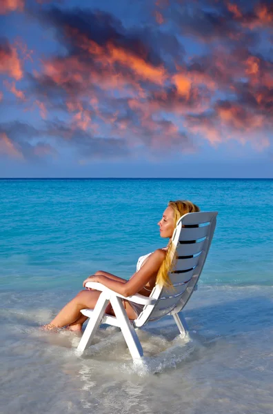 Young pretty woman in a beach chair at ocean — Stock Photo, Image
