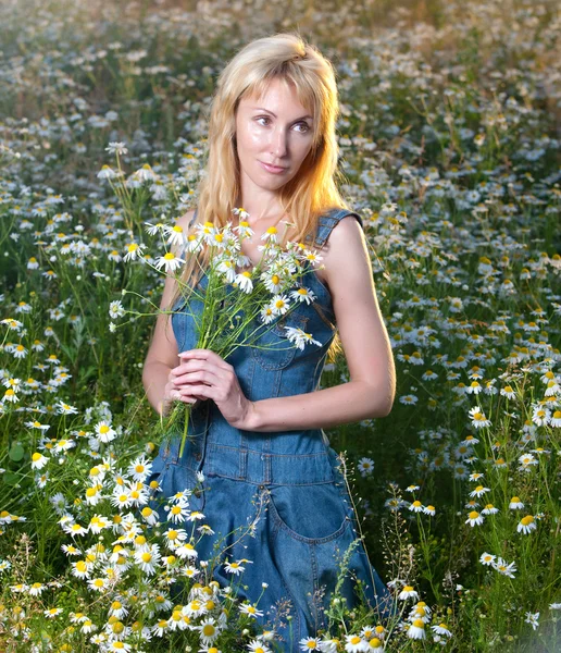 Wanita muda cantik di lapangan dengan karangan bunga camomiles — Stok Foto