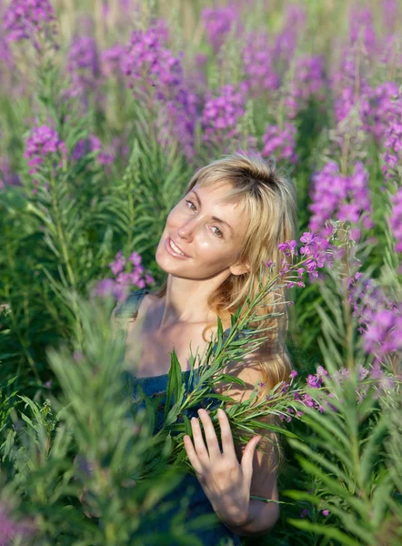 Portrait of the happy young woman in flowers blooming sally — Stock Photo, Image