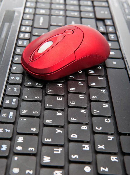 The red computer mouse on the black keyboard — Stock Photo, Image