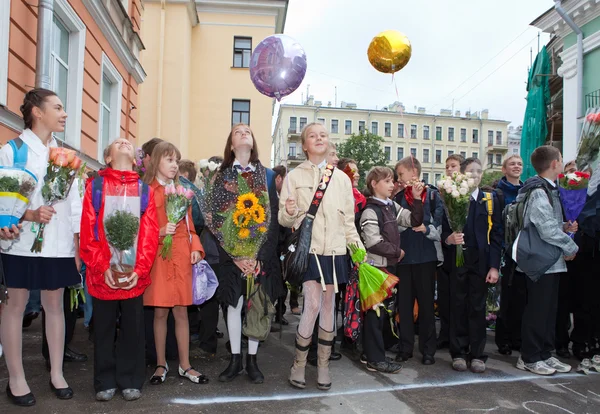 Dzieci z kwiatami w pobliżu szkoły na pierwszy dzień w szkole na 1 września 2011 r. w saint-petersburg, Federacja Rosyjska — Zdjęcie stockowe