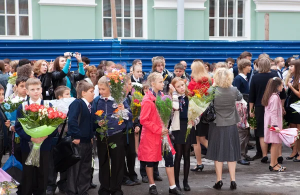 Children with flowers near the School on the first day of school on September 1, 2011 in Saint-Petersburg, Russia — Stock Photo, Image