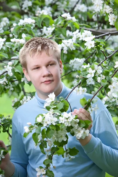 젊은 남자, 꽃이 만발한 사과 나무 근처에 서 십 대 — 스톡 사진