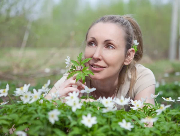 Glade içinde erken sprin çiçek açması kardelen üzerinde güzel bir genç kadın — Stok fotoğraf