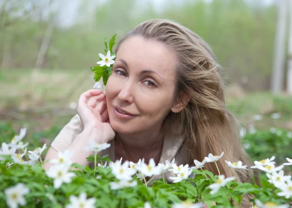 Piękna młoda kobieta na polanie kwitnących Przebiśniegi w początku sterow — Zdjęcie stockowe