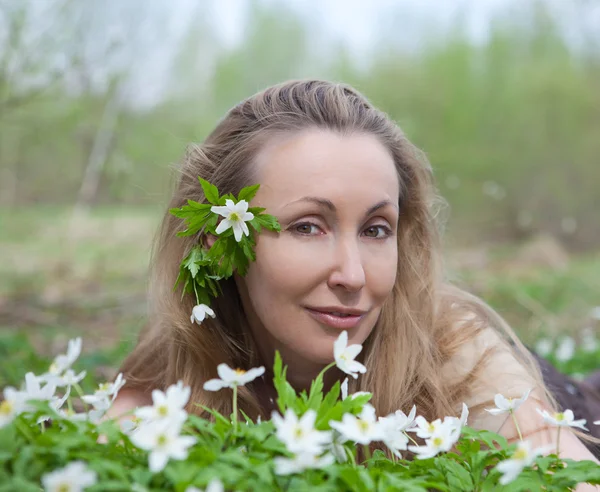 Piękna młoda kobieta na polanie kwitnących Przebiśniegi w początku sterow — Stockfoto