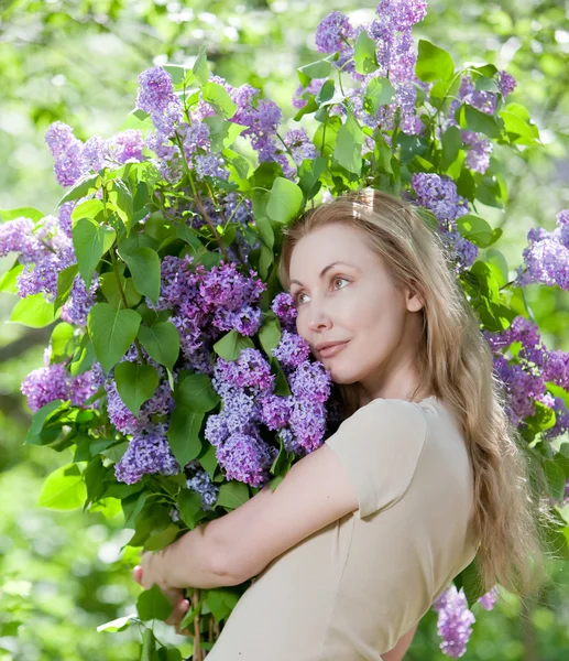 Giovane donna felice in parco con un mazzo grande di un lilla — Foto Stock