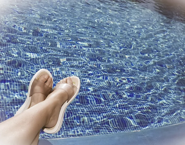 Pieds dans des pantoufles de plage au bord de la piscine, avec un effet rétro — Photo