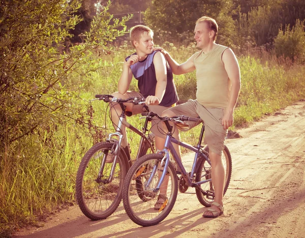 O pai com o filho em bicicletas, com um efeito retro — Fotografia de Stock