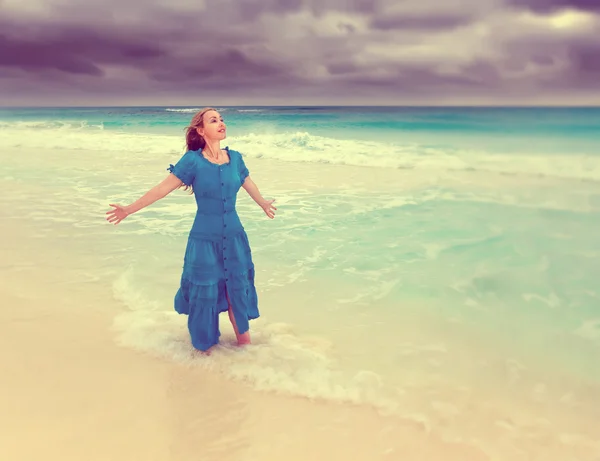 Žena v dlouhé modré šaty v příboji bouřlivé moře, s retro efekt — Stock fotografie