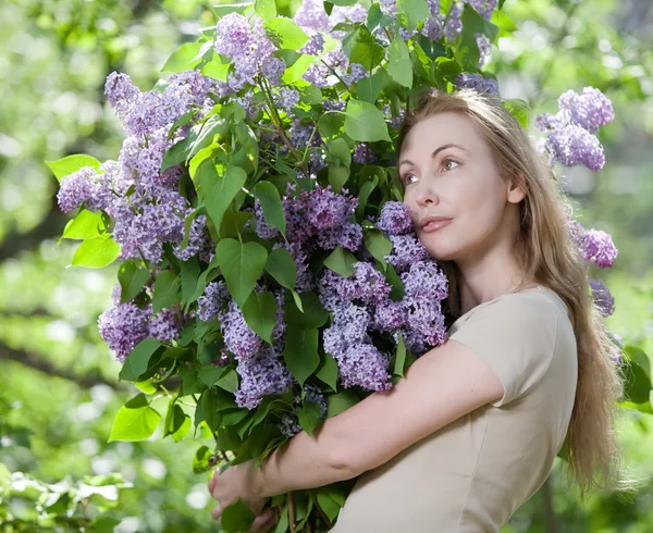 Giovane donna felice in parco con un mazzo grande di un lilla — Foto Stock